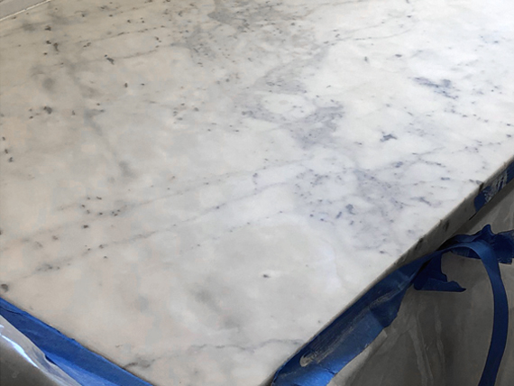 After honing, this marble has a silky, low-reflective surface that will make future etching less visible.