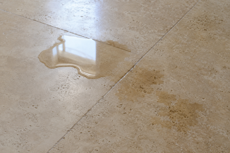 Water being absorbed into a natural travertine floor, demonstrating the porous nature of travertine stone and how moisture can penetrate unsealed surfaces.